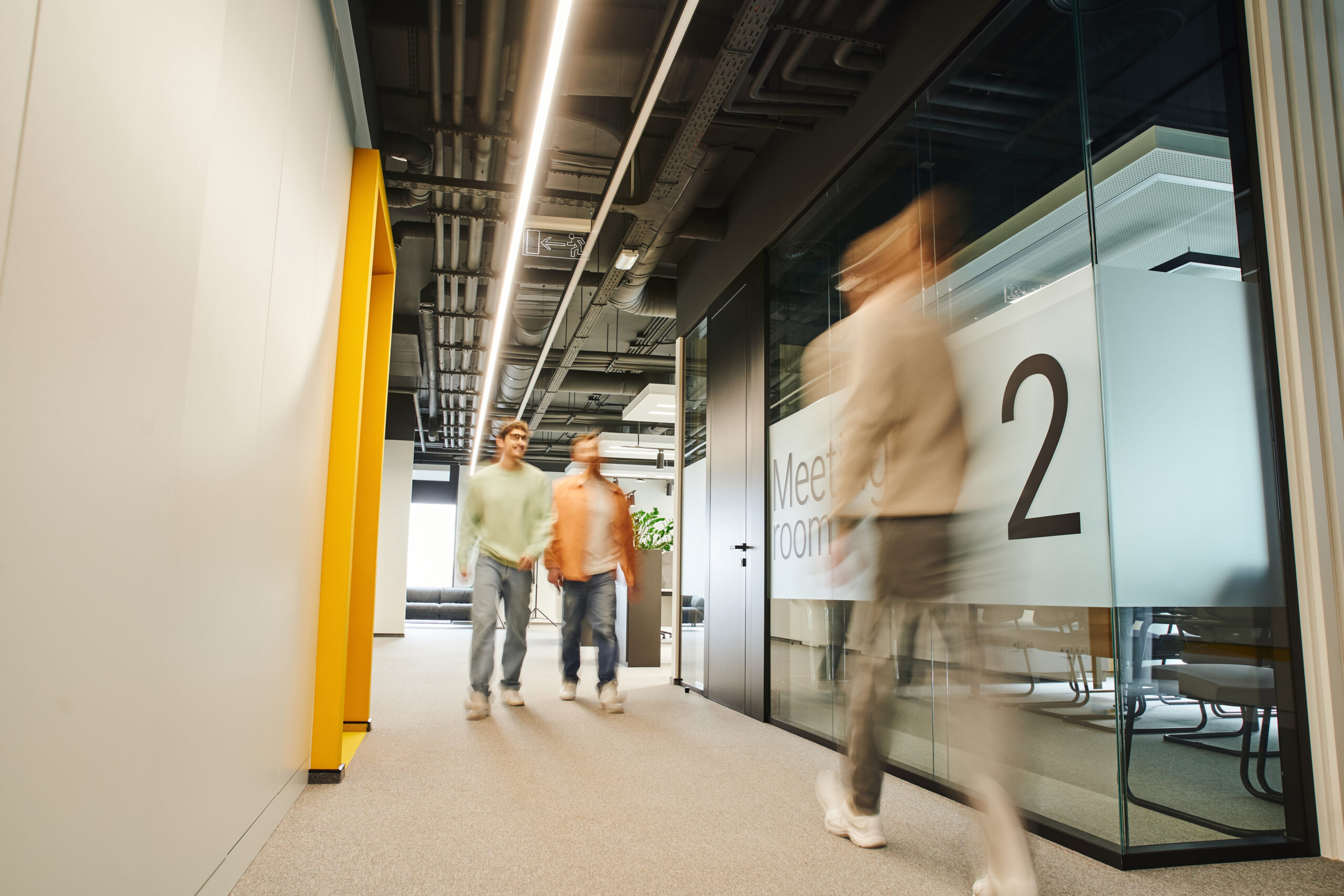 motion blur of modern business people working in corridor along meeting room in contemporary coworking environment with high tech interior, dynamic business concept